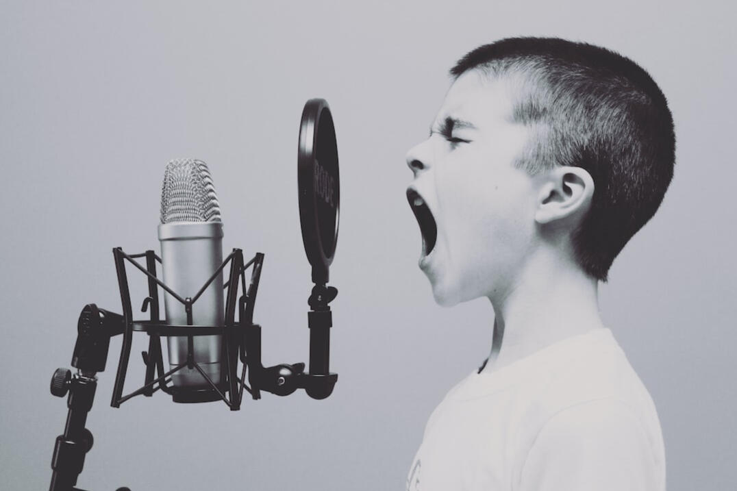 An autistic child screams into a dynamic microphone.